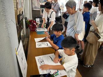 子供たちが真剣にマンガを描く様子