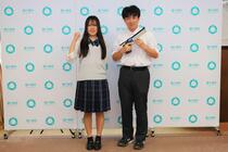 選手たちがビームピストルを持って記念撮影の様子