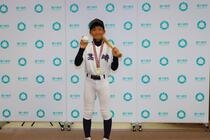 石塚選手がバットとボールを持って記念撮影の様子