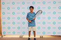 小柴選手がラケットを持って記念撮影の様子
